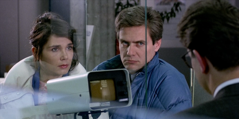 A man and a woman looking at a man behind a window glass in The Seventh Continent