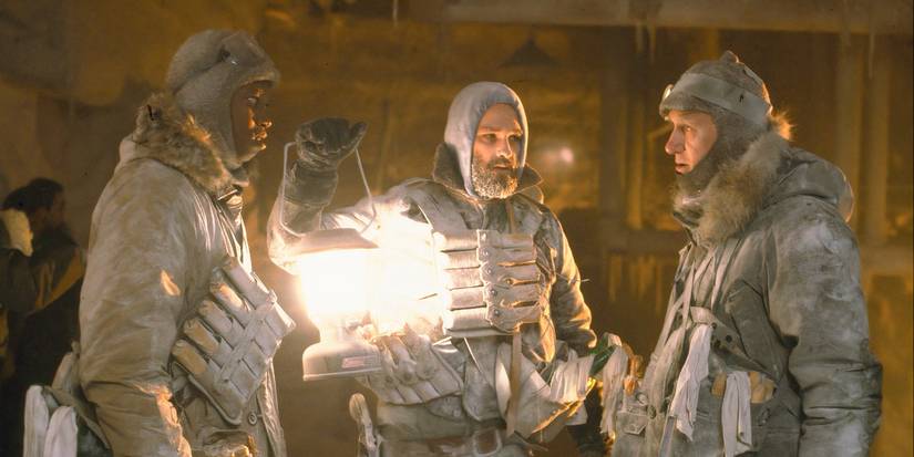 Nauls (TK Carter), MacReady (Kurt Russell) y Garry (Donald Moffat) están en marcha hablando mientras MacReady lleva una antorcha a The Thing.