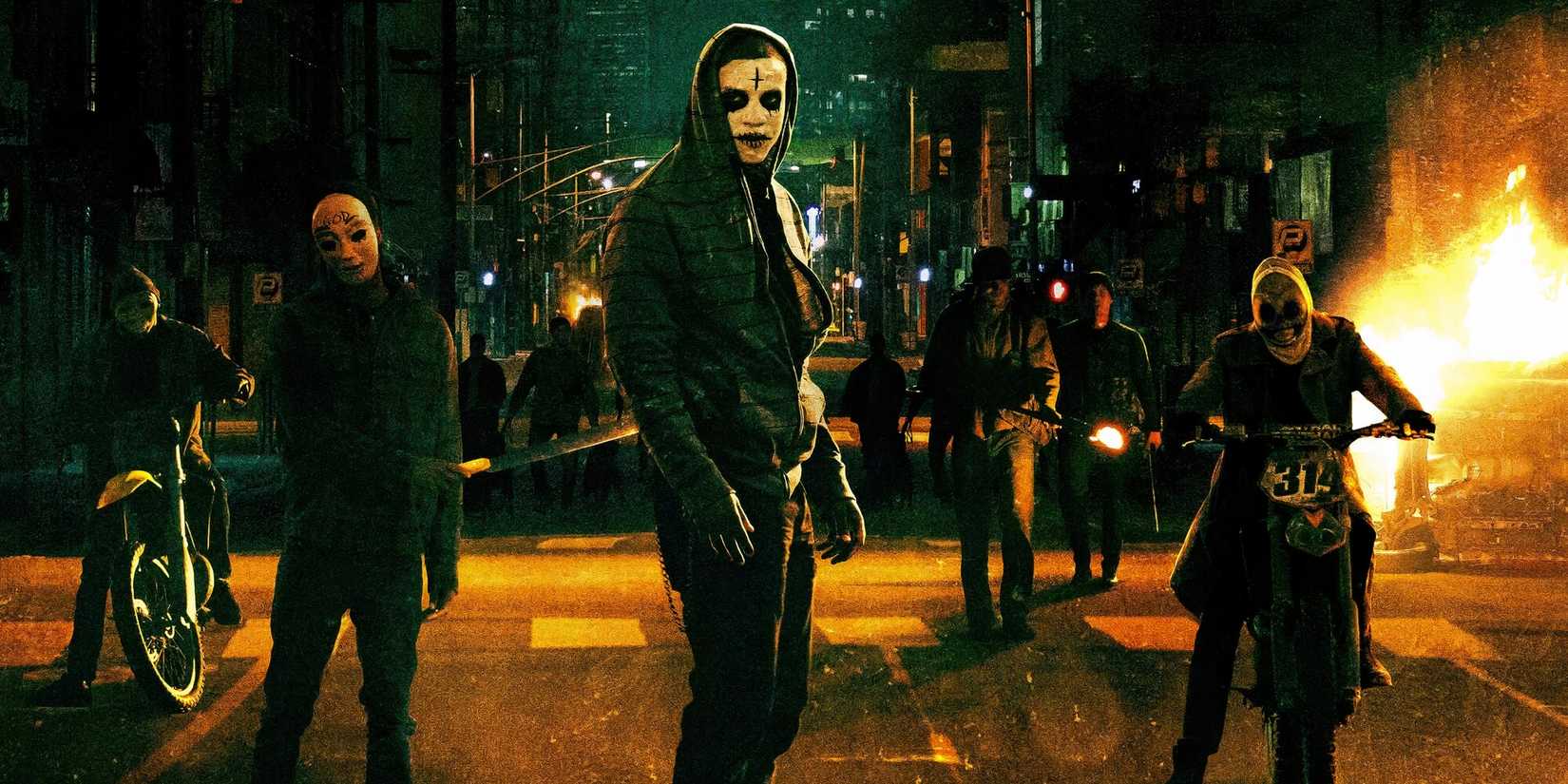 A group of people wearing face paint and elaborate masks in the middle of the street in 'The Purge: Anarchy'