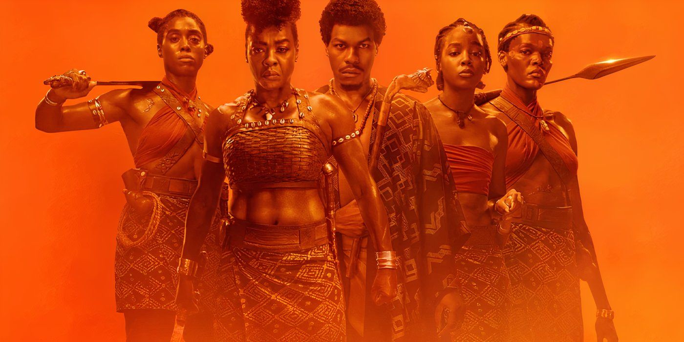 Promotional image for 'The Woman King' featuring a group of warriors brandishing weapons amidst an orange backdrop