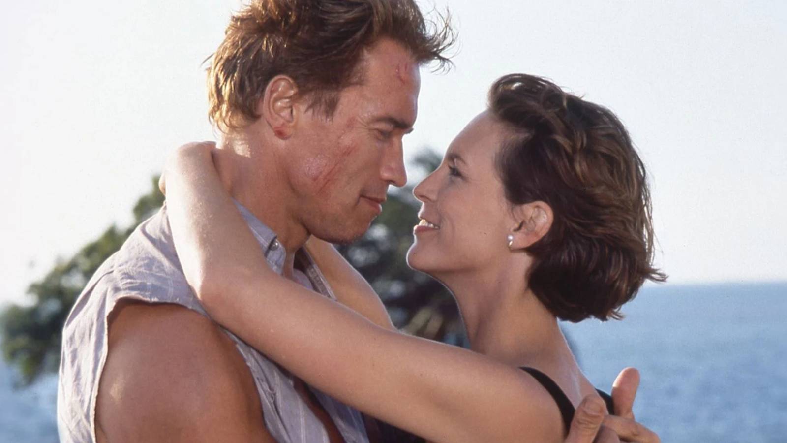 Harry and Helen, played by actors Arnold Schwarzenegger and Jamie Lee Curtis, embracing in James Cameron's True Lies (1994).