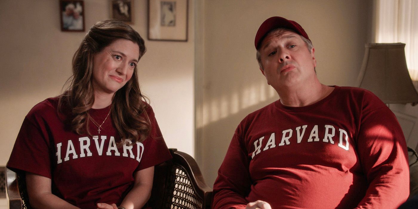 Zoe Perry as Mary & Lance Barber as George wear Harvard shirts & sit on the couch in Young Sheldon
