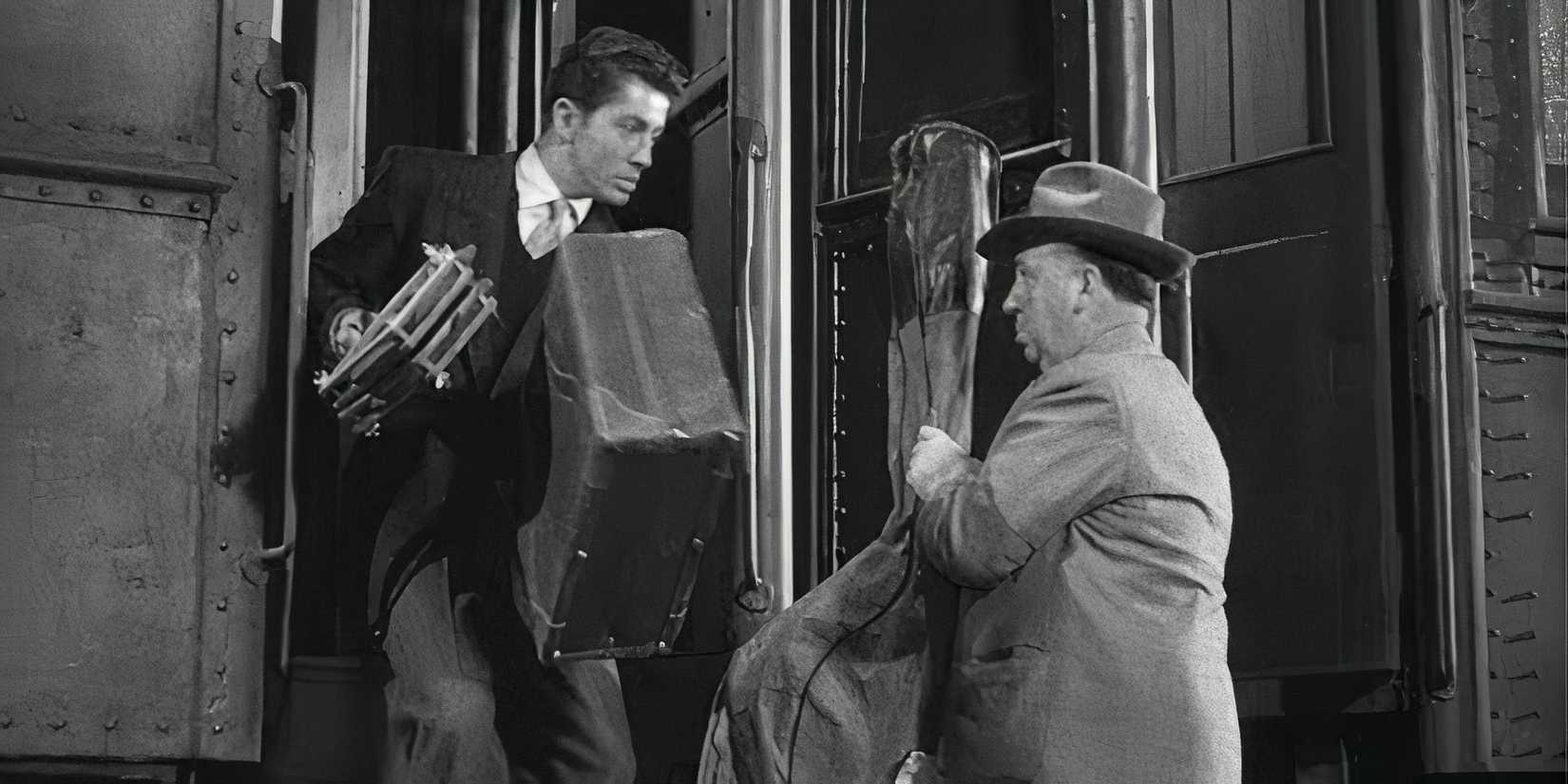 Alfred Hitchcock getting onto a train with a cello while Farley Granger hops off in Strangers on a Train (1951)