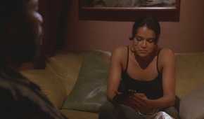 Ana Lucia (played by Michelle Rodriguez), sits on the sofa in the hatch, holding a gun moments before being betrayed by Michael (Harold Perrineau), in Lost’s Season 2 Episode Two for the Road.