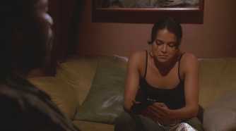 Ana Lucia (played by Michelle Rodriguez), sits on the sofa in the hatch, holding a gun moments before being betrayed by Michael (Harold Perrineau), in Lost’s Season 2 Episode Two for the Road.
