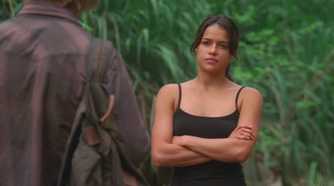 Ana Lucia (played by Michelle Rodriguez), confronts Sawyer (Josh Holloway) in the jungle with her arms crossed in Lost’s Season 2 Episode ‘Two for the Road.’