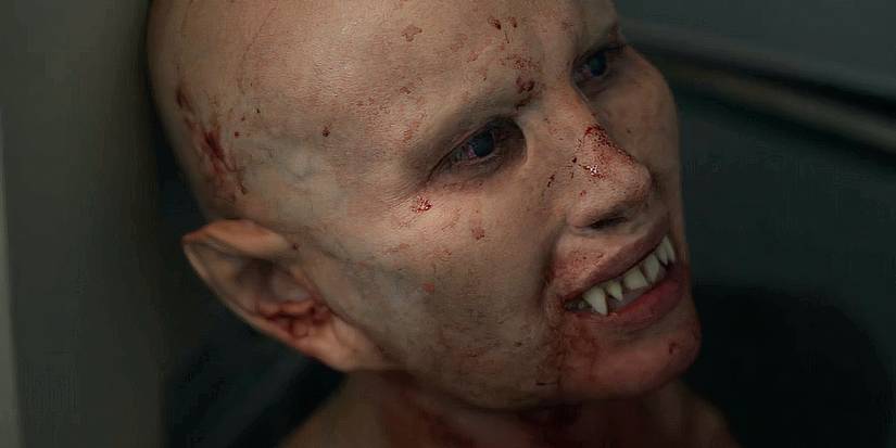 A close up of Nadja (Peri Baumeister) looking sad despite her blood-splattered face and visible fangs in Blood Red Sky