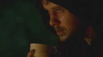 A sweat-soaked Charlie (Dominic Monaghan), battles heroin withdrawals while drinking tea in Lost.