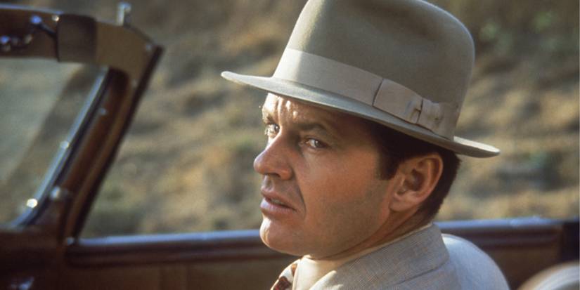 Jack Nicholson olhando por cima do ombro e carrancudo em um carro em Chinatown