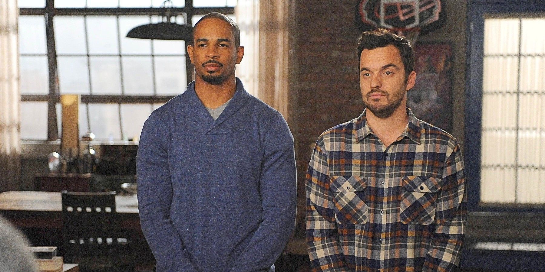 Coach and Nick standing with blank expressions in New Girl.