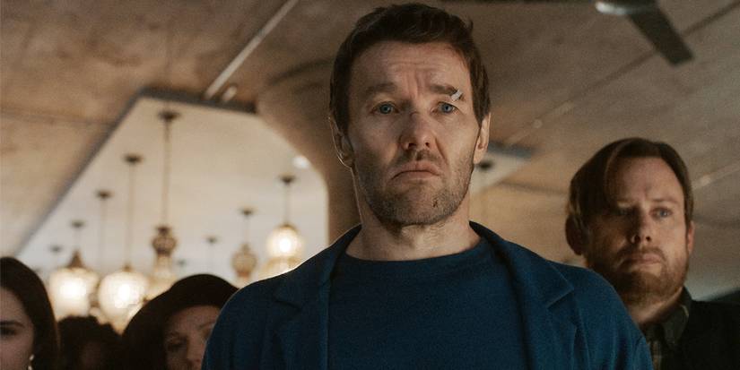 A bruised and cut Joel Edgerton looks off-camera with concern with Jimmi Simpson behind him in Dark Matter.