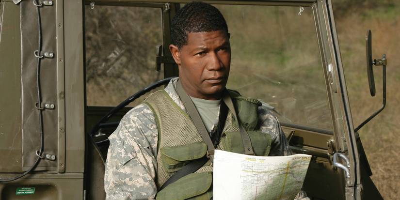 Dennis Haysbert holding a map by a military vehicle in The Unit