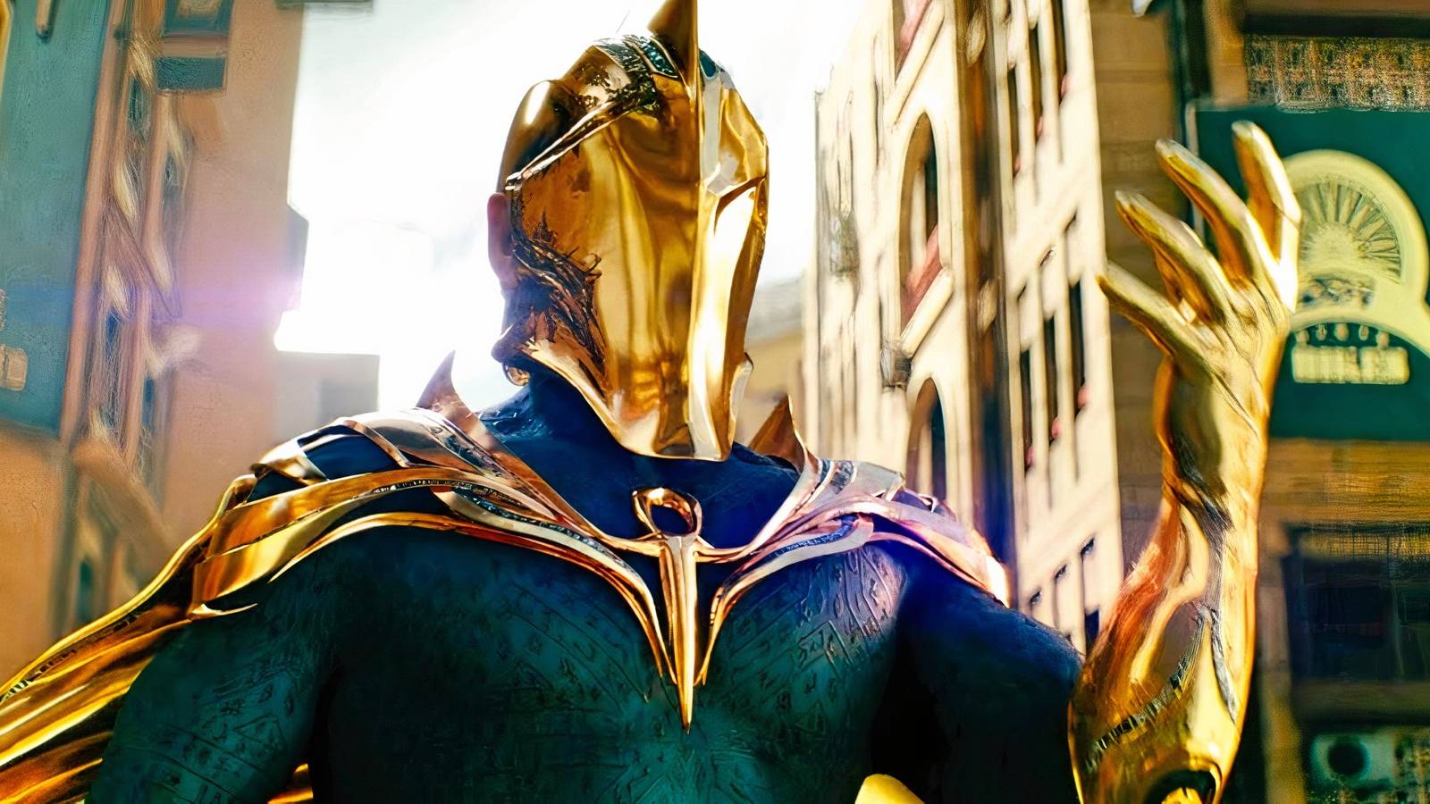 Dr. Fate dons his golden helmet and raises his hand to cast a spell in Black Adam.