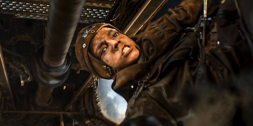 Furiosa with an enraged expression looking down at someone in Furiosa.