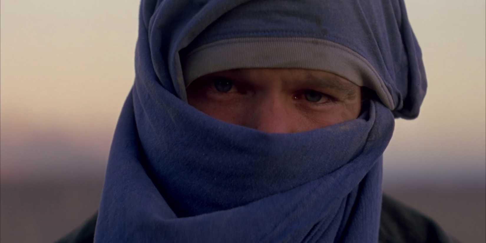 Gerry 2002 - Matt Damon in extreme closeup, wearing his shirt as a makeshift turban, staring into camera
