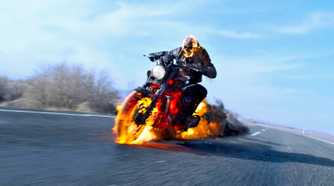 Ghost Rider (played by Nicolas Cage), rides his flaming motorbike down a freeway in Spirit of Vengeance.