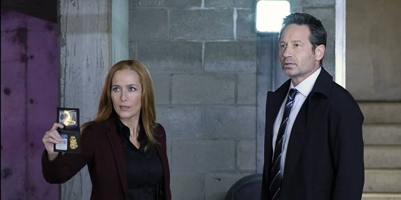 Gillian Anderson flashes her badge while standing beside her partner David Duchovny from The X-Files