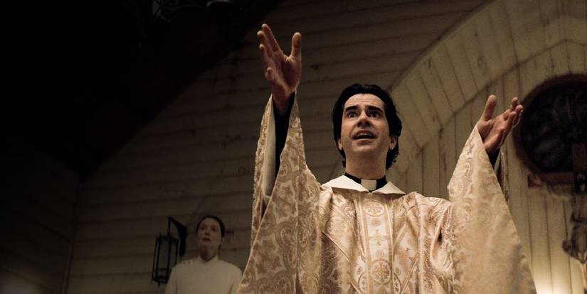 Hamish Linklater na meia -noite Missa levantando as mãos no ar na missa.