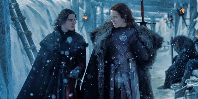 Harry Collett and Tom Taylor walk as it snows at the Wall in House of the Dragon Season 2