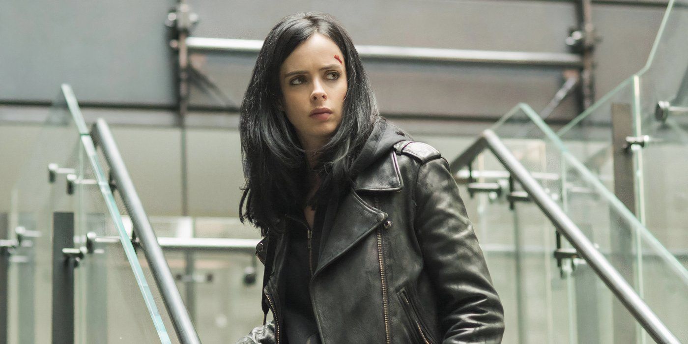 Jessica Jones (Krysten Ritter) standing on a set of stairs and looking slightly to the right.