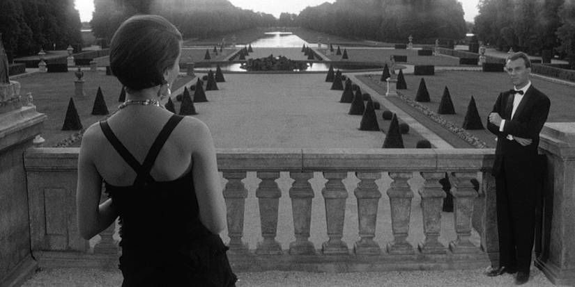 A woman on a dress looking at a large garden in Last Year at Marienbad