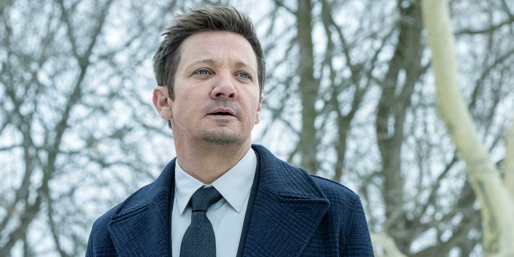 Jeremy Renner as Mike McLusky in a suit in the forest in the daylight in Season 3 of Mayor of Kingstown