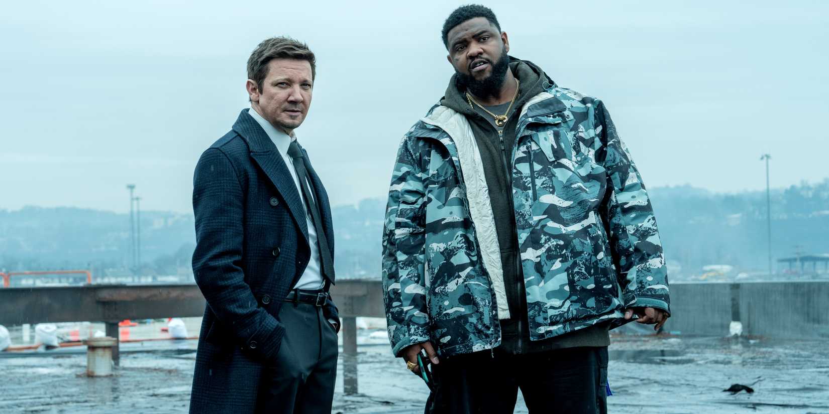 Jeremy Renner as Mike McLusky and Tobi Bamtefa as Bunny standing side by side outdoors in Mayor of Kingstown