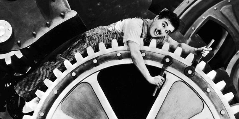 Still of Charlie Chaplin atop a spinning cog in Modern Times (1936)
