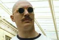 Charles Bronson (Tom Hardy) staring a guard down behind his sunglasses in Bronson