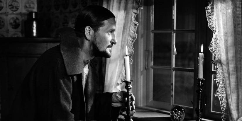 A man looking outside a window in Ordet