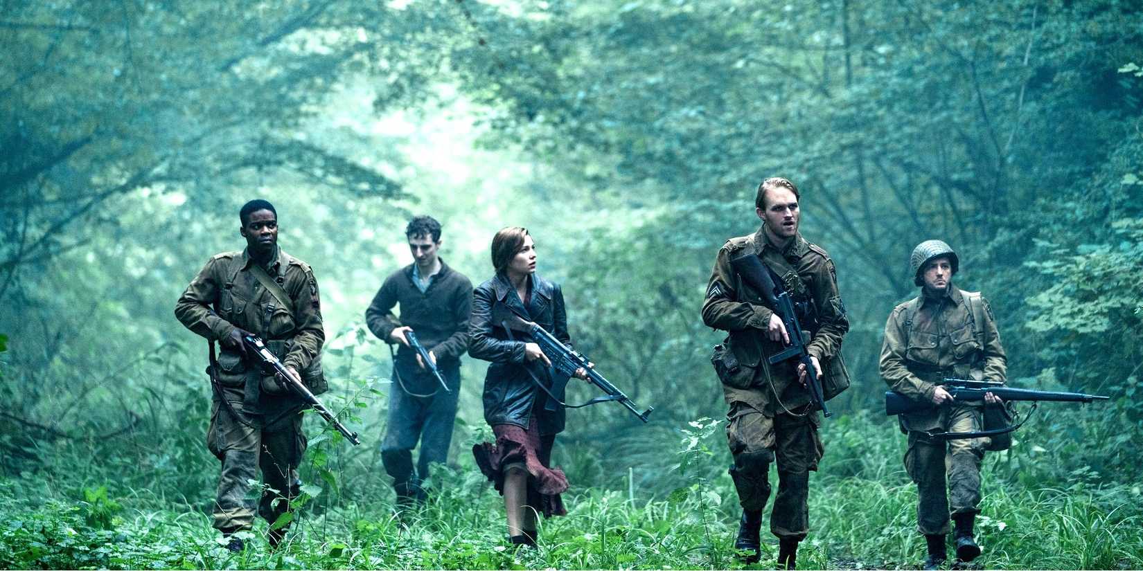 The ensemble cast of Overload walking through the forest