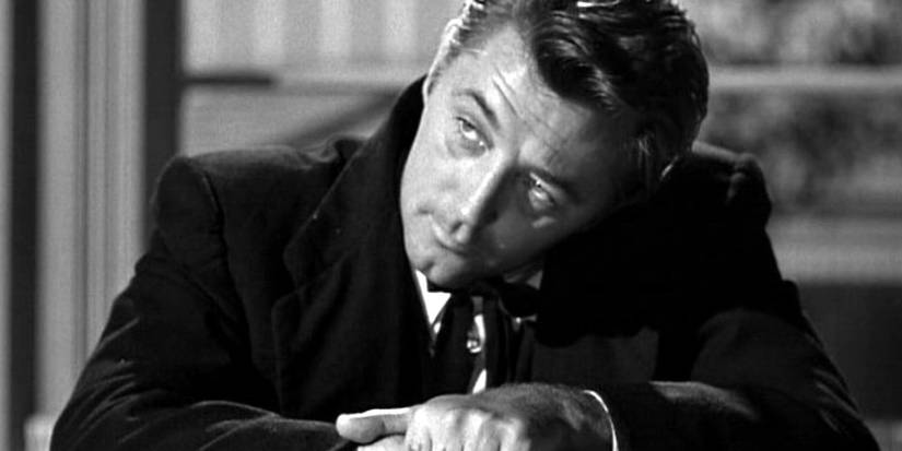 Robert Mitchum as "Preacher" Harry Powell looking up at a person offscreen in The Night of the Hunter.