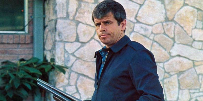 William Devane as Charles Rane holding a rifle and looking back in 'Rolling Thunder' 