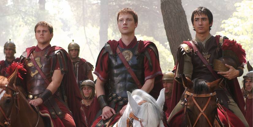 A group of Roman soldiers sit on horseback in a forest in the series Rome.