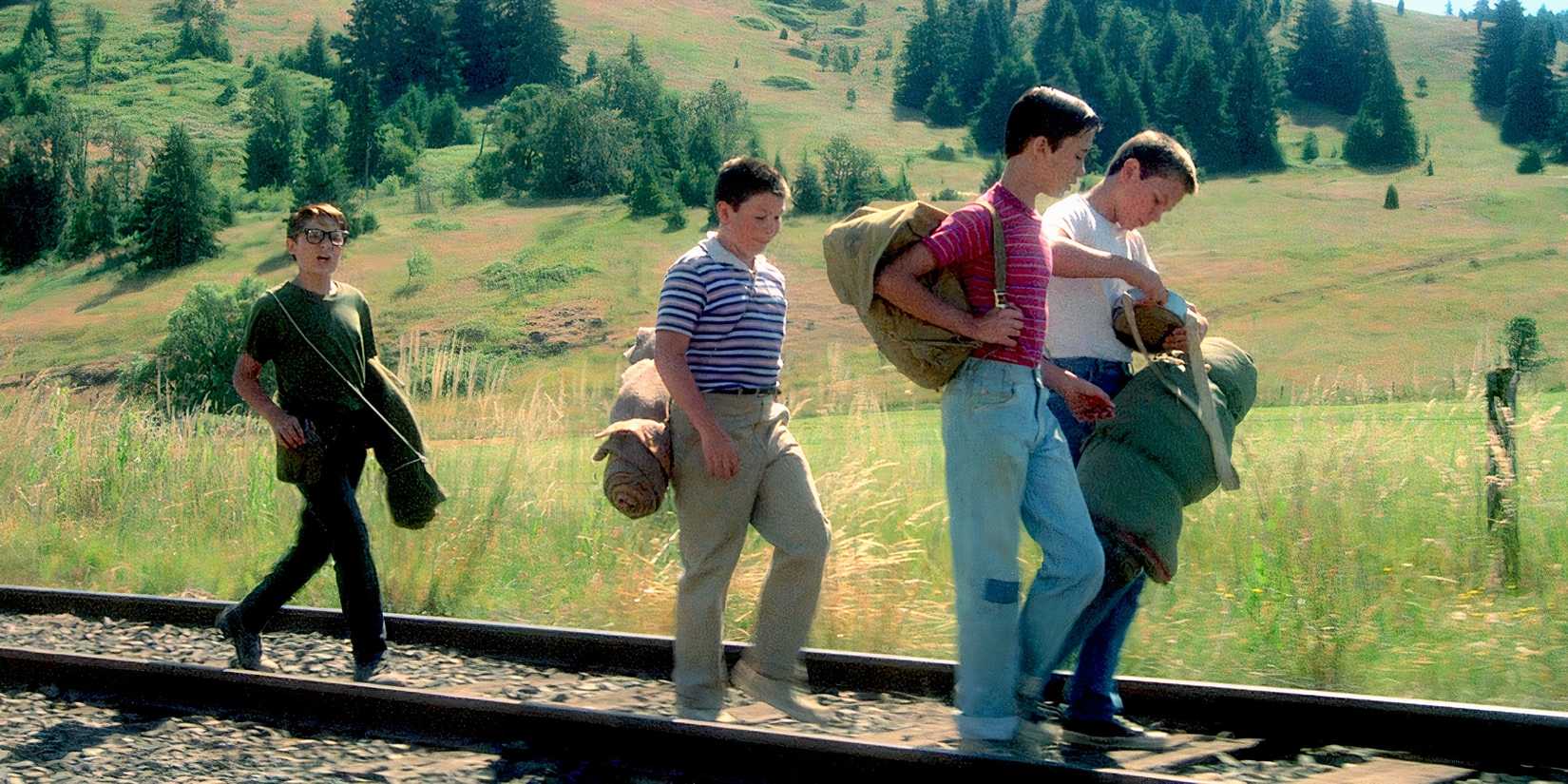 Teddy (Corey Feldman), Vern (Jerry O'Connell), Gordie (Will Wheaton), and Chris (River Phoenix) walk along the train tracks in 'Stand by Me' (1986)