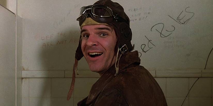 Navin Johnson (Steve Martin) stands in a toilet cubicle with an aviator cap on as he looks to someone shocked.