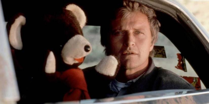 John Ryder (Rutger Hauer) in a car with a teddy bear in 'The Hitcher'