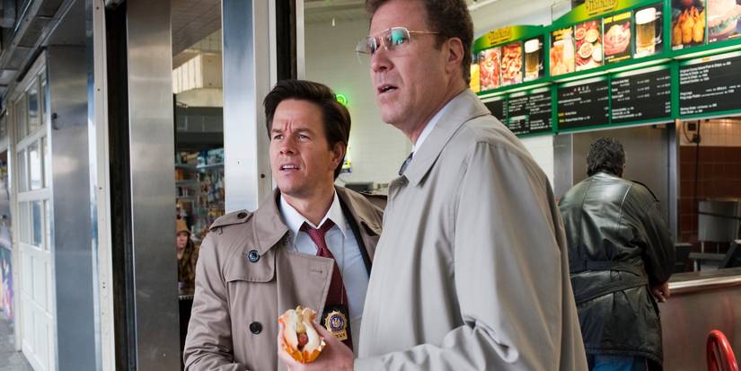 Will Ferrell's Allen looking shocked and holding a hot dog next to Mark Wahlberg's Terry in The Other Guys