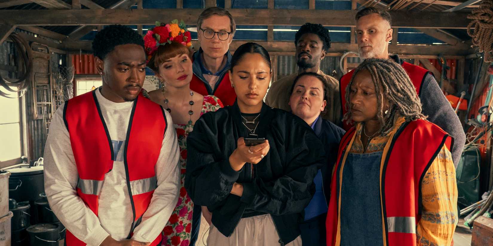 Stephen Merchant with Eleanor Tomlinson, Jessica Gunning & the cast of The Outlaws looking at a cell phone