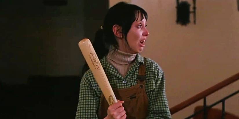 Wendy Torrance, played by Shelley Duvall, holds a baseball bat in terror on a staircase in The Shining