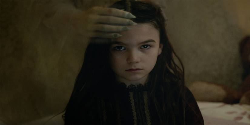 Flora with a spectral hand on her forehead in in The Turning​​​​​​​.