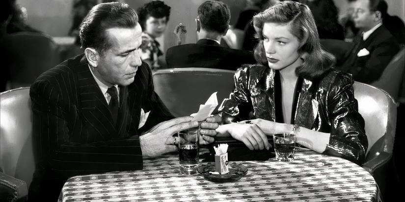 Marlowe (Humphrey Bogart) sits across from Vivian (Lauren Bacall)  in a fancy restaurant in The Big Sleep.