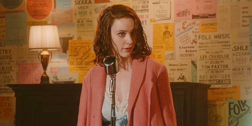 Midge Maisel onstage in front of a wall of flyers in the pilot episode of The Marvelous Mrs. Maisel.