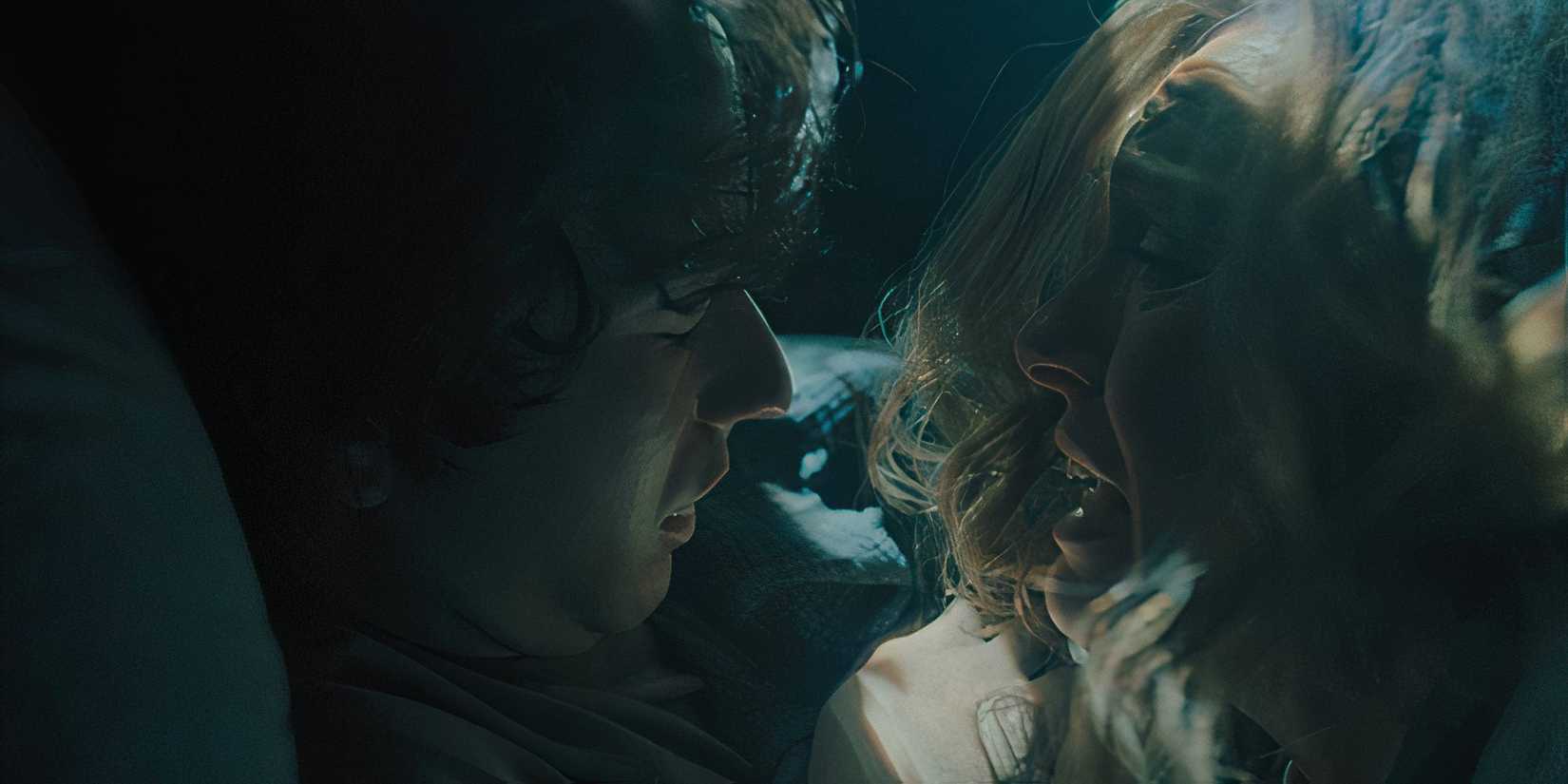 Toni Collette as Annie looking closely at Alex Wolff as Peter in bed in Hereditary.