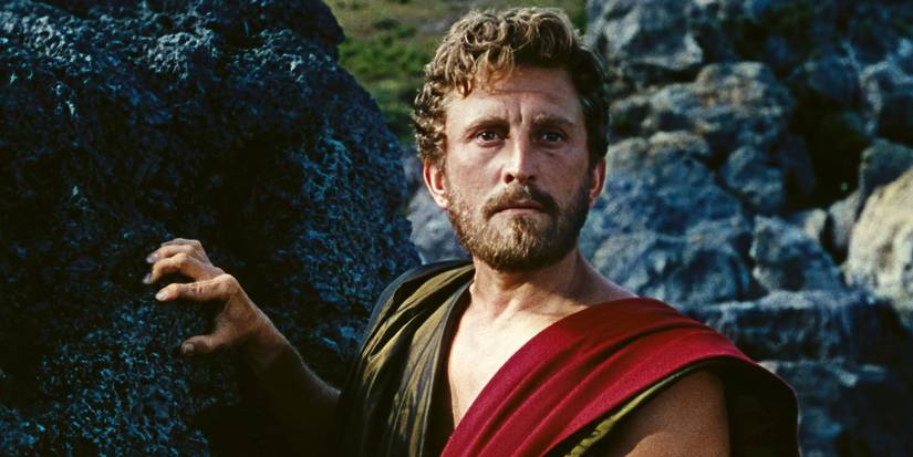 Ulysses has his hand on a large boulder and looks into the distance in Ulysses. 