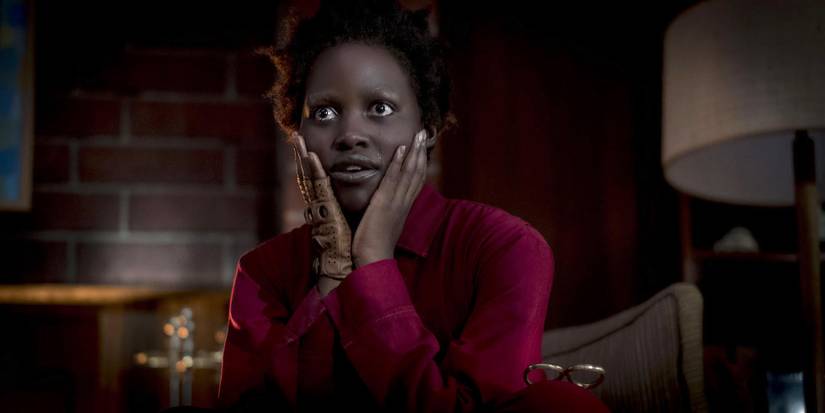 Lupita Nyong'o as Red with her hands on her cheeks in Us.