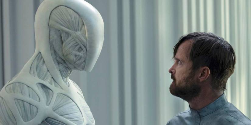 Aaron Paul as Caleb Nichols staring at a faceless white robot in Westworld.