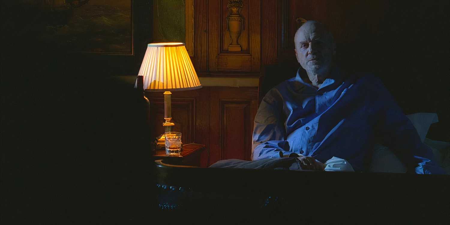 Charles Widmore (played by Alan Dale), sits up next to bed, where Benjamin Linus (Michael Emerson), has snuck in to threaten him in Lost’s Season 4 Episode ‘The Shape of Things to Come.’
