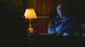 Charles Widmore (played by Alan Dale), sits up next to bed, where Benjamin Linus (Michael Emerson), has snuck in to threaten him in Lost’s Season 4 Episode ‘The Shape of Things to Come.’