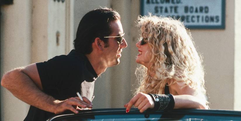 Nicolas Cage's Sailor leaning close to kiss Laura Dern's Lula in Wild at Heart 